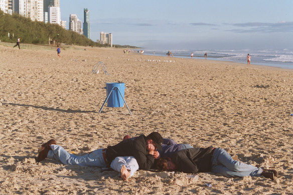 Schoolies asleep on the beach at Surfers Paradise in a previous decade.