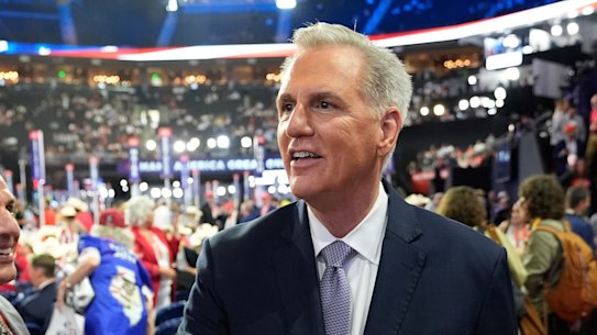 Former Speaker of the House Kevin McCarthy shakes hands with a delegate on the floor of the Republican National Convention.