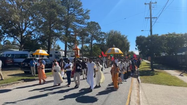 A religious procession passes along a Northgate street lined with caravan and motorhome companies.