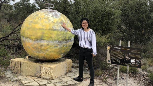 Wenjing Zheng next to one of the sculptures on the solar system walk at the Gravity Discovery Centre in Gingin. 