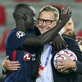 Awer Mabil celebrates with FC Midtjylland director Claus Steinlein after clinching UEFA Champions League qualification last month