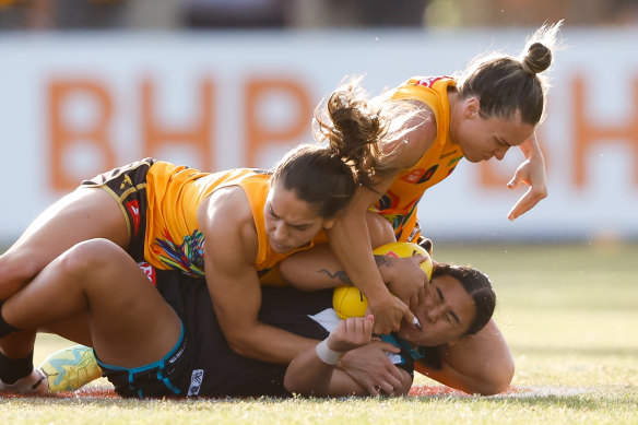 Hawthorn teammates Emily Bates and Mattea Breed make their tackle on Port Adelaide’s Hannah Ewings stick.
