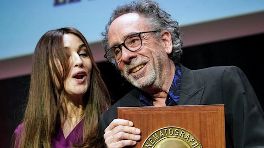 Director Tim Burton with the award he won at the Lumiere Festival in Lyon, with presenter Monica Bellucci.