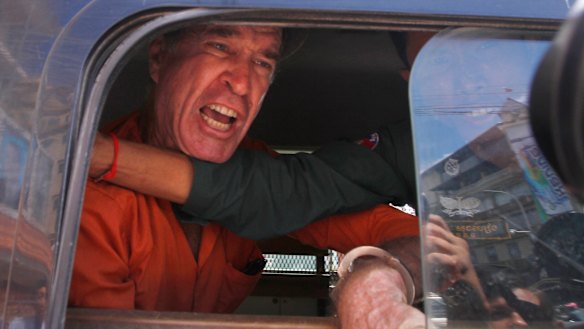 Australian filmmaker James Ricketson speaks from a prison truck during a lunch break at Phnom Penh Municipal Court on Friday.