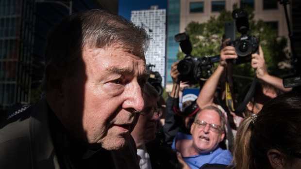 George Pell outside Victoria's County Court, where hecklers yelled that the cardinal was going to "burn" and "rot" in hell.