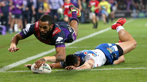 Josh Addo-Carr of the Storm scores a try under pressure from Roger Tuivasa-Shack of the Warriors.