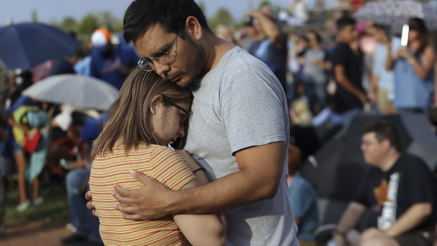 Mamy Garcia comforts his girlfriend Jackie Saucedo at the Hope Border Institute prayer vigil on Sunday in El Paso, Texas, a day after the mass shooting.