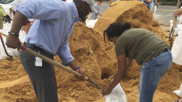Tallahassee mayor and Democratic gubernatorial candidate Andrew Gillum, left, helps Eboni Sipling fill up sandbags in Tallahassee, Florida, on Monday.