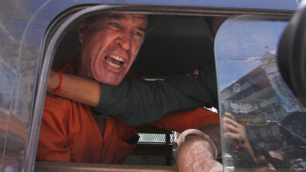 Australian filmmaker James Ricketson speaks from a prison truck during a lunch break at Phnom Penh Municipal Court on Friday.