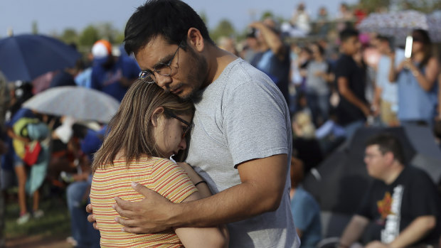 Mamy Garcia comforts his girlfriend Jackie Saucedo at the Hope Border Institute prayer vigil on Sunday in El Paso, Texas, a day after the mass shooting.