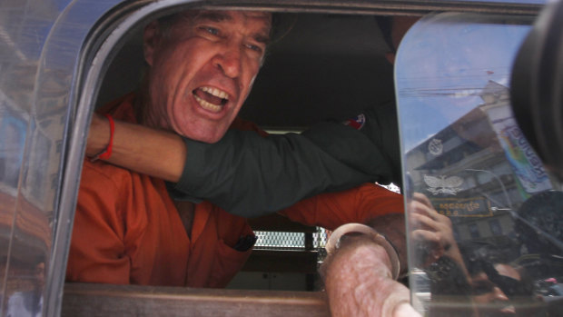 Australian filmmaker James Ricketson speaks from a prison truck during a lunch break at Phnom Penh Municipal Court on Friday.