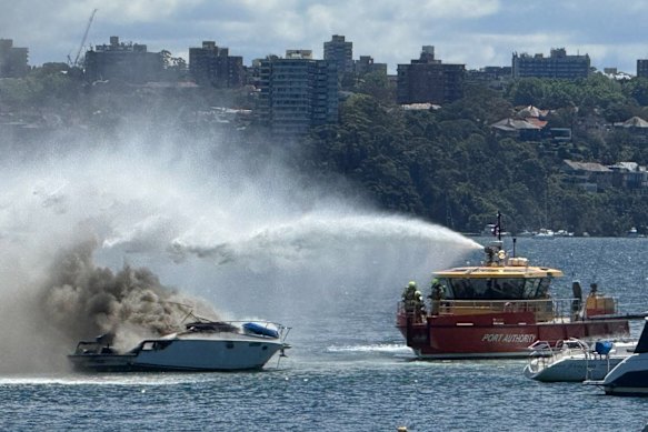 A Port Authority tug boat douses the flames.
