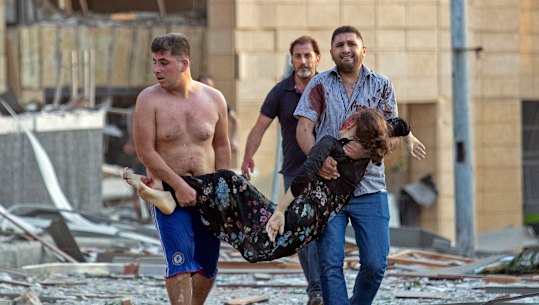 A wounded woman is evacuated after a massive explosion in Beirut.
