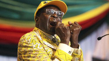 Robert Mugabe, then-President, clenches his fists as he delivers his speech at his party's annual conference in 2012.
