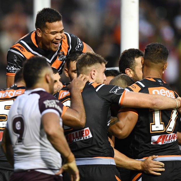 Wests Tigers players celebrate after Robbie Farah's match-sealing try in the opening round of the 2019 season, which Lawrence watched from home.