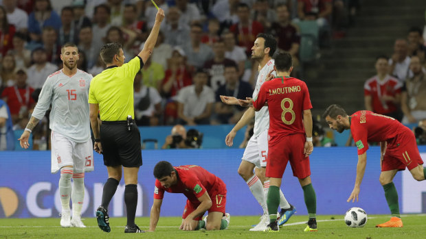 Referee Gianluca Rocchi from Italy shows yellow card to Spain's Sergio Busquets .