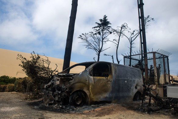 A burnt out vehicle and the remains of the Blue Waves campsite at the foot of the Dunes of Pilat in Gironde, France.