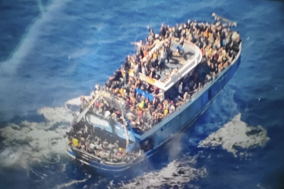 Scores of people covering practically every free stretch of deck on a battered fishing boat that later capsized and sank off southern Greece.