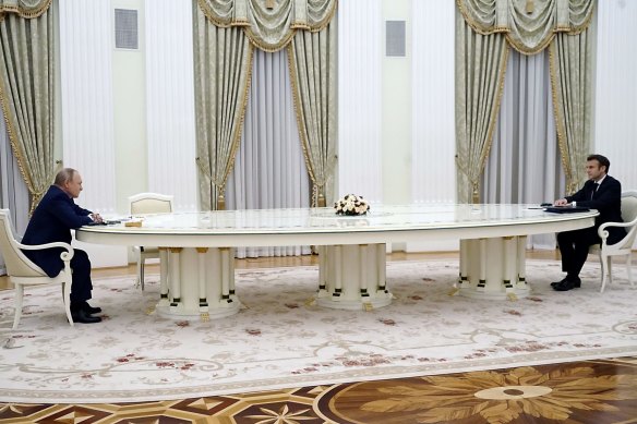 Macron (right) met with Putin in 2022 over one of the Russian president’s notoriously long meeting tables, urging him to “calm things down” in  Europe.