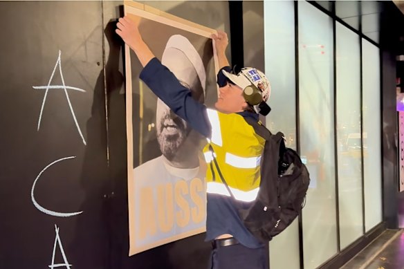 Lennon putting up a poster of Man Haron Monis, the man responsible for deadly Lindt Cafe siege in Sydney in 2014.