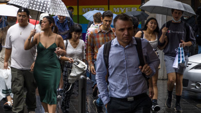 Brollies at the ballot box: Temperatures drop in Brisbane for election day