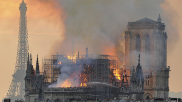 Flames and smoke rise from the blaze after the spire toppled over on Notre-Dame.