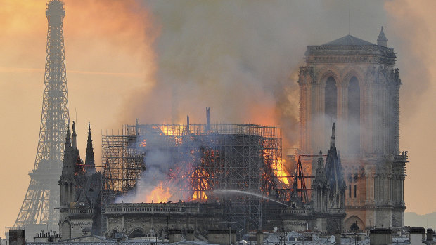Flames and smoke rise from the blaze after the spire toppled over on Notre-Dame.