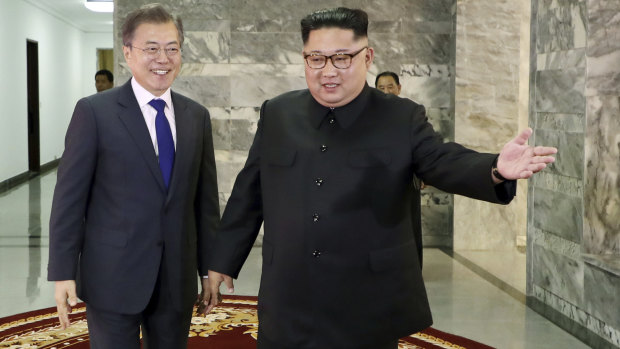 South Korea's Moon Jae-in, left, is guided by North Korean leader Kim Jong-un, right, at the northern side of Panmunjom in North Korea during their surprise meeting on Saturday.