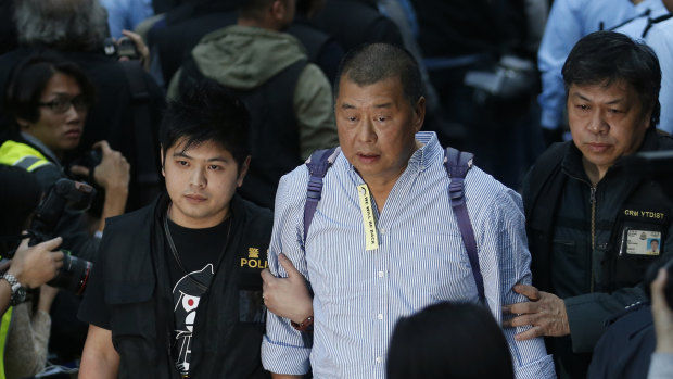 Hong Kong media magnate Jimmy Lai, centre, is taken away by police officers at the occupied area outside government headquarters in Hong Kong. 