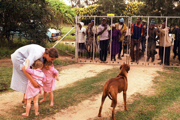 Farm manager's wife Pippa van Rechteren, left, and her two-year-old twins are held captive by Zimbabwe war veterans in their house on their white-owned commercial farm in 2000.