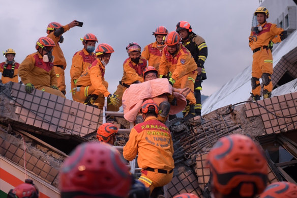 A person being rescued by firefighters following the earthquake.