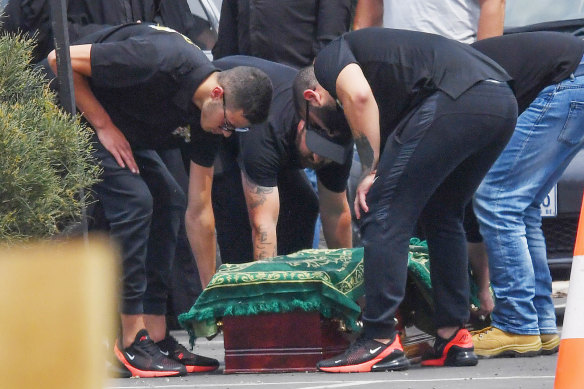 Nabil Maghnie's sons stand over his coffin.
