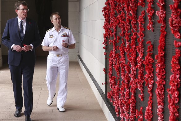 Mr Gee places poppies on the Roll of Honour during an event to mark the 80th anniversary of the sinking of the HMAS Sydney.
