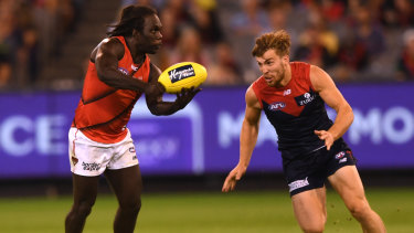 Pressure point: Demon Jack Viney lines up Essendon's Anthony McDonald-Tipungwuti.