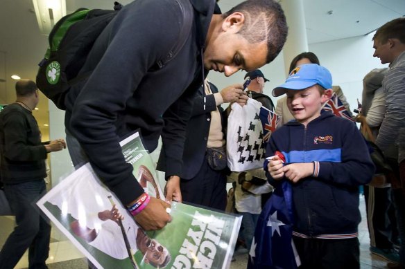 Nick Kyrgios signs autograph for Charlie Camus, 7, as he arrives at the airport in 2014.