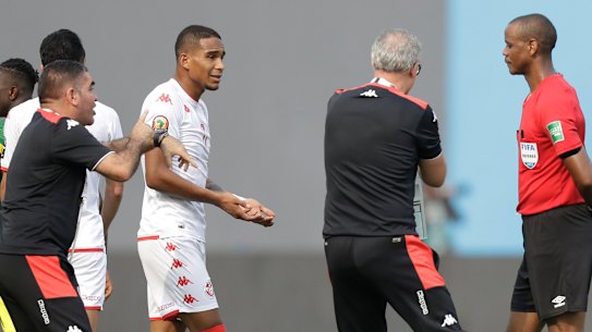 Tunisia’s head coach Mondher Kebaier, centre, gestures to the referee Janny Sikazwe of Zambia, claiming that he ended the match early in the African Cup of Nations  match between Tunisia and Mali.