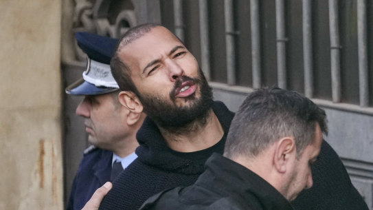 Police officers escort Andrew Tate to the Court of Appeal in Bucharest, Romania on February 1.