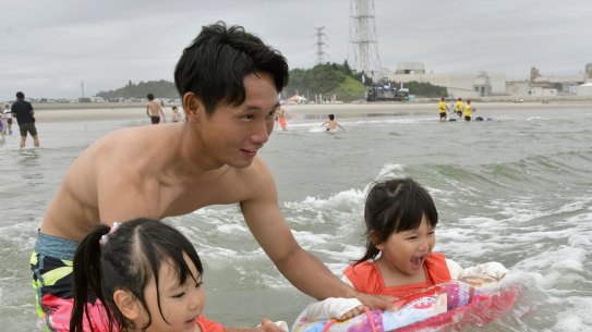 A family plays in the water at Kitaizumi Kaisui beach in Minamisoma, Fukushima Prefecture, after the beach opened to the public for the first time since 2011. 