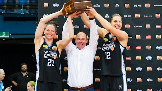 Kelsey Griffin, coach Paul Goriss and Marianna Tolo hold the grand final trophy.