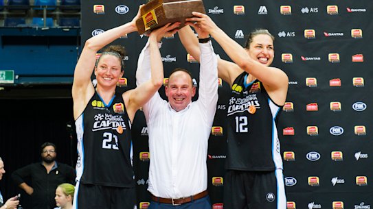Kelsey Griffin, coach Paul Goriss and Marianna Tolo hold the grand final trophy.