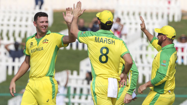 Australia’s Josh Hazlewood, left, is congratulated by teammates after dismissing Quinton de Kock during the Twenty20 World Cup match between South Africa and Australia in Abu Dhabi.
