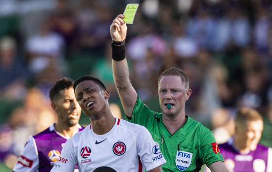 Keanu Baccus of the Wanderers gets a yellow card against Perth Glory on Sunday.