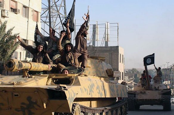 Members of Islamic State ride tanks during a parade in Raqqa, Syria, in 2014.