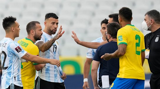 Brazil and Argentina players talk as the game is interrupted by health authorities.