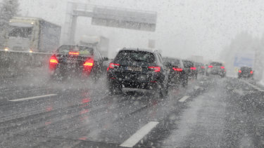 Cars make their way through heavy snow fall in Noesslach near Innsbruck, Austria.