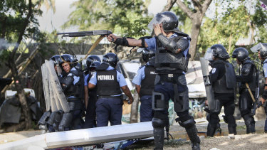 A Nicaraguan police officer aims his weapon at protesting students on Friday.