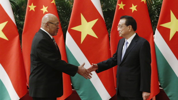 Suriname's President Desi Bouterse shakes hands with Chinese Premier Li Keqiang before a meeting at the Great Hall of the People this week.