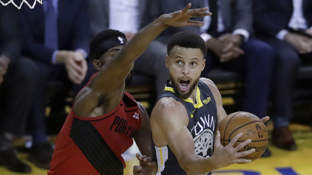 The Warriors' Steph Curry (right) shoots against the Trail Blazers' Maurice Harkless.