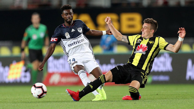 Melbourne Victory's Elvis Kamsoba is tackled by Louis Fenton of the Wellington Phoenix.