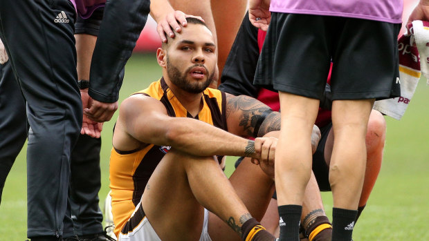 Winged: Hawk Jarman Impey receives treatment after injuring his knee during the win over Geelong at the MCG.